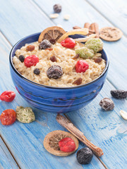 oatmeal with dried fruits on a blue wooden background