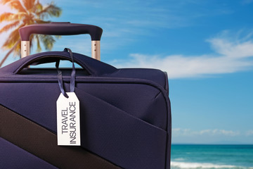 Blue suitcase with Travel Insurance label closeup