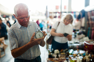 Loving senior family couple choosing vintage things on street market
