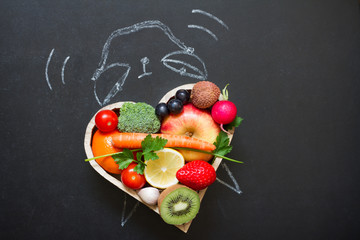 Time alarm on diet and healthy lifestyle concept with fruits and vegetables and  clock on blackboard