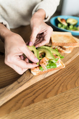 Adult woman preparing an healthy avocado sandwich
