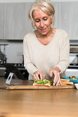 senior woman cutting vegetables