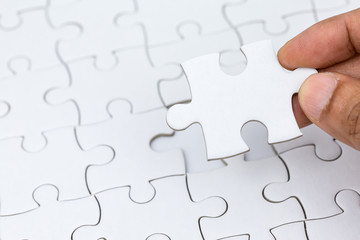 Hand holding piece of jigsaw puzzle