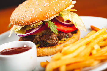 Fast food. Homemade hamburger and french fries on white plate.
