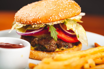 Fast food. Homemade hamburger and french fries on white plate.