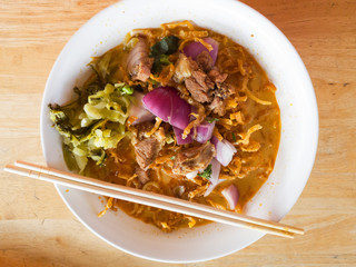 Noodle dish in a yellow beef curry.