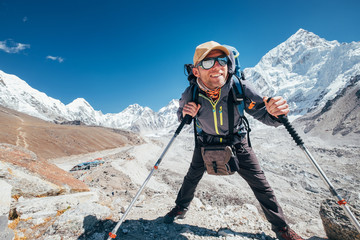 Portrait of smiling Hiker man with Nuptse 7861 m peak and Gorak shep settlement background with...