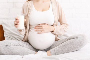 Pregnant woman enjoying fresh milk, close up