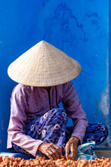Unidentified Vietnamese merchant  wearing traditional Vietnamese style conical hat 