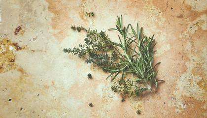 Fresh rosemary and thyme on rustic stone background. From above. Copy space