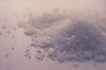 White sea salt on the table, pile closeup, side view.