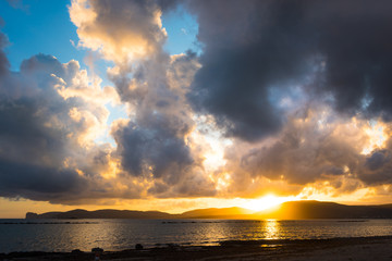 Dark clouds over Alghero shore at sunset