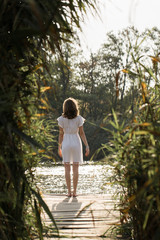 Portrait of a young beautiful girl in reeds in retro style in a light dress.
