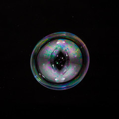 Colorful creative sphere soap bubble floating with a black background