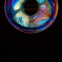 Colorful creative sphere soap bubble floating with a black background