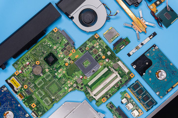 Parts of a modern computer. The insides of a laptop on a blue background, flat lay composition