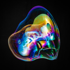 Colorful creative amorphous soap bubble floating with a black background - obrazy, fototapety, plakaty