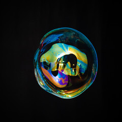 Colorful creative amorphous soap bubble floating with a black background