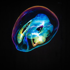 Colorful creative amorphous soap bubble floating with a black background