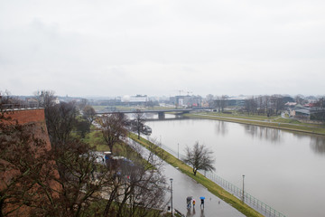 Panoramic view of the city of Krakow and the Vistula River from the observation deck of the Wawel Castle at Christmas in rainy weather.