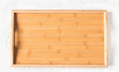 Wooden tray on light background. Empty tray in bed