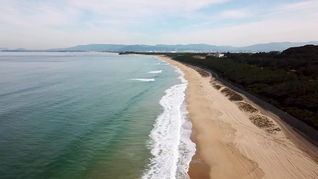 高度を下げながら砂浜に打ち寄せる波の上空を進む 空撮 トラックアップ 海の中道海岸_v143_00803_DJI_0010_2