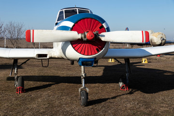 Old airplanes. Green and blue corncob. Sports plane of the 19th century. Until now they fly. Touch the antiquity. Propeller and wings. Airplane repair. Aerodrome. Blue sky. Sunny.