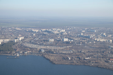 Fototapeta premium Aerial view of the city. Foggy day, sunny weather and blue sky. 400 meters above the ground. Small houses and river view. Winter sky.