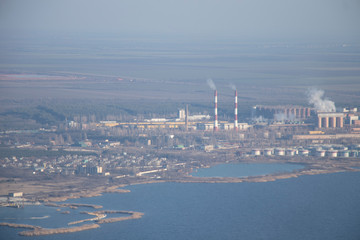 Aerial view of the city. Foggy day, sunny weather and blue sky. 400 meters above the ground. Small houses and river view. Winter  sky.