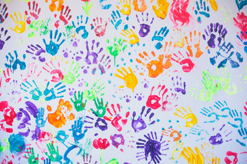 White wall with colorful multicolored hand prints print