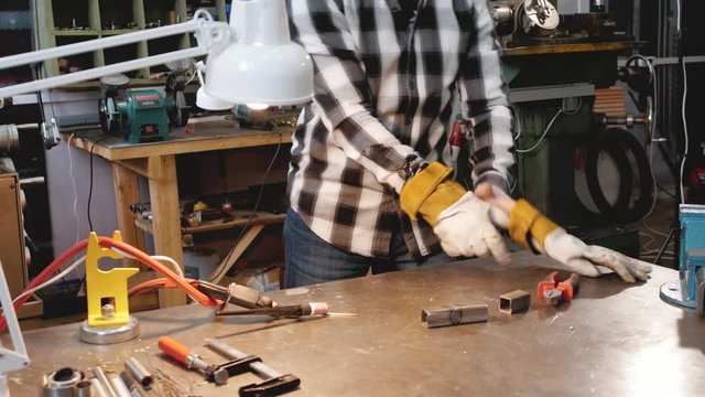 blacksmith welder in protective mask works with metal steel and iron using a welding machine, bright sparks and flashes