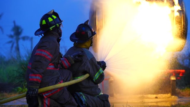A firefighter assists in extinguishing a burning fire.