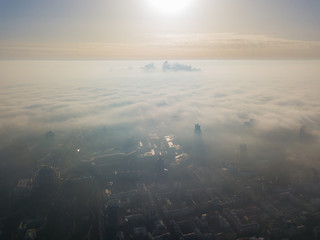 Aerial drone view. A foggy morning in Kiev, the silhouettes of houses are visible through the autumn fog.