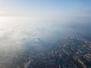 Fototapeta na wymiar Aerial drone view. A foggy morning in Kiev, the silhouettes of houses are visible through the autumn fog.