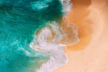 Aerial view of the turquoise ocean waves on the beach. Beautiful sandy beach with turquoise sea....