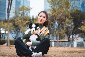 Naklejka na ściany i meble Young Asian girl holding puppy Border Collie