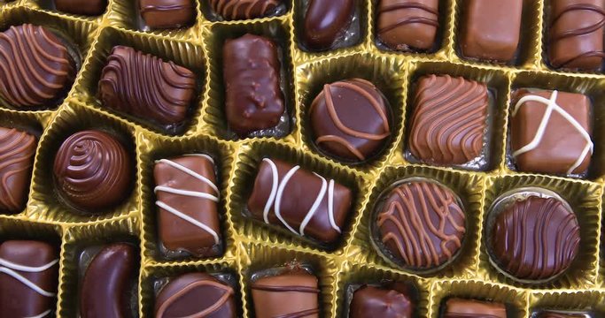 Selection of pralines with milk and dark chocolate in box. Loving chocolate and sweets concept. Dolly shot 4k