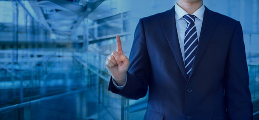 ポイントを指し示す30代男性ビジネスマン-抽象背景