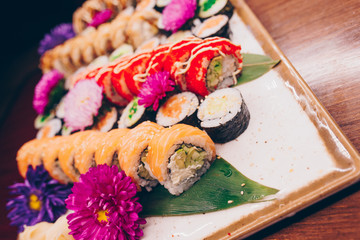 A large set of Delicious sushi rolls view from above Flat Lay . A lot assortment Philadelphia roll Dishes from Japanese raw fish  in one plate in traditional restaurant. Copy Space Japan menu service