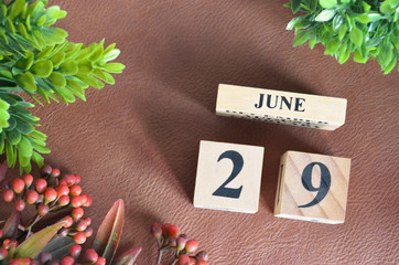 June 29, Number cube design with flower on brown lether background.