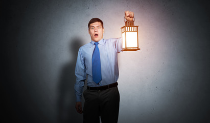 Horrified businessman holding glowing lantern © adam121