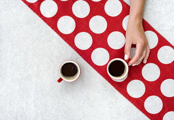 Black coffee in red cups on retro polka dot linen napkin.