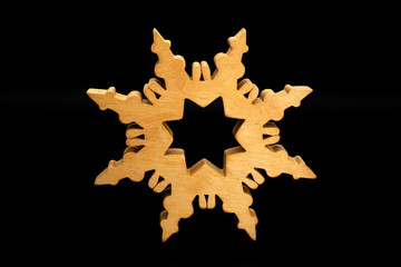 A beautiful star made of wood standing on a black background