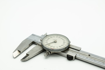 A dial caliper lying on a white background