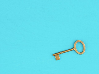 Old bronze antique key on blue wooden background with copy space