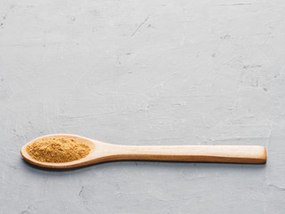 Spice masala in wooden spoon on gray concrete background. Indian cuisine, ayurveda, naturopathy concept