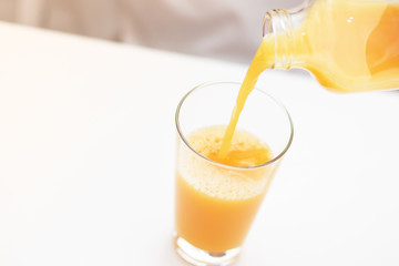 Orange juice fills a glass. Morning breakfast.