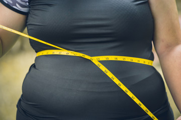 girl waist belly fat woman with waist tape measure closeup shot.