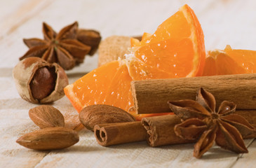 image of anise, cinnamon, almond nut, orange slices on the table