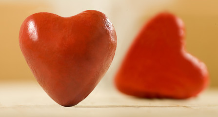 Fototapeta premium image of stylized two red hearts on wooden boards as a symbol of love and fidelity